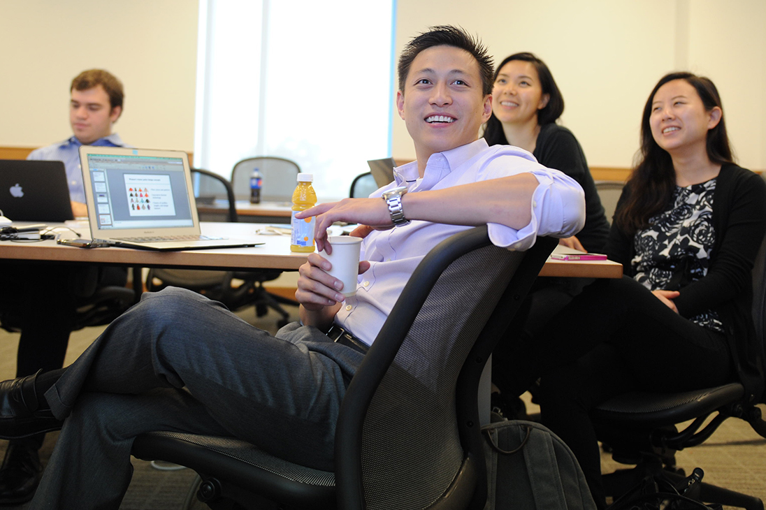 4 students engaged with someone off camera in LLM classroom at BU Law