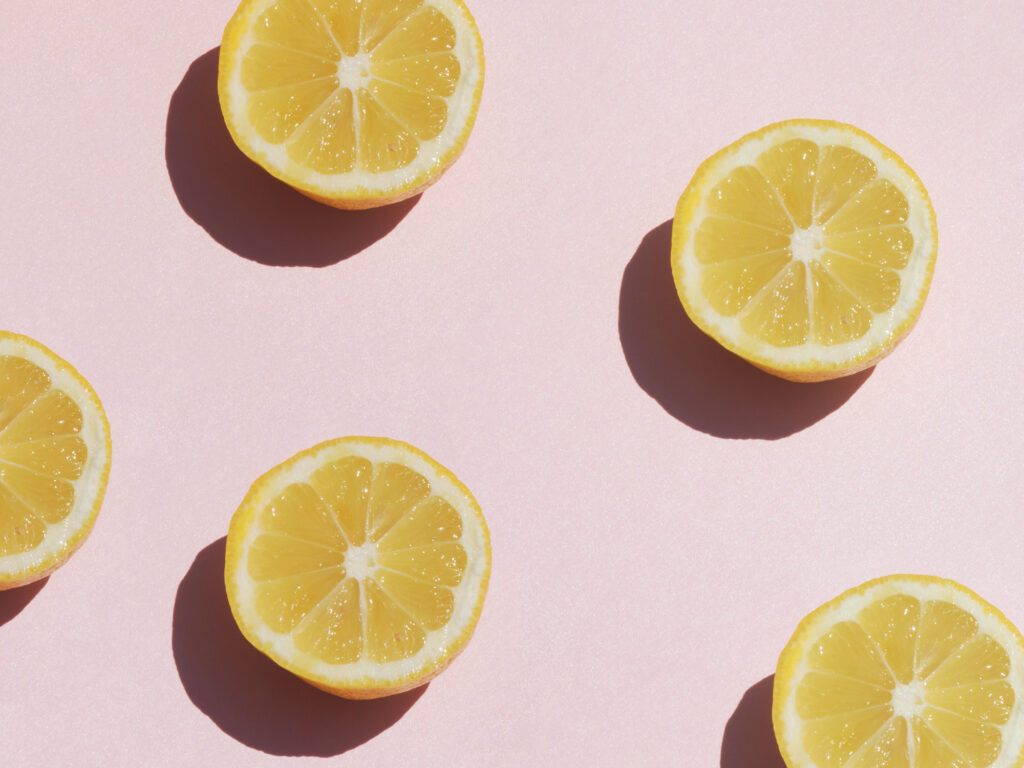 Sliced lemons against a pink background