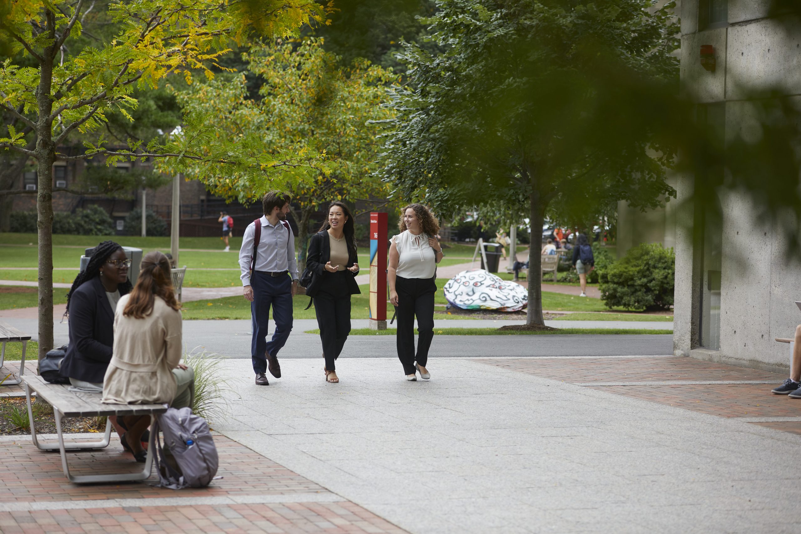 three students walking in courtyard