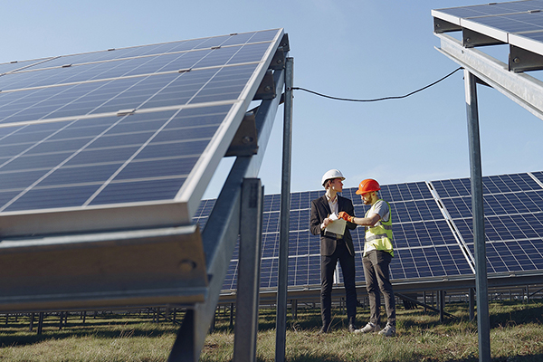 men standing by solar panels