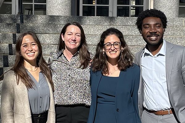 Professor Madeline Meth and three others pose for a photo on the steps of a courthouse in Boston, MA.