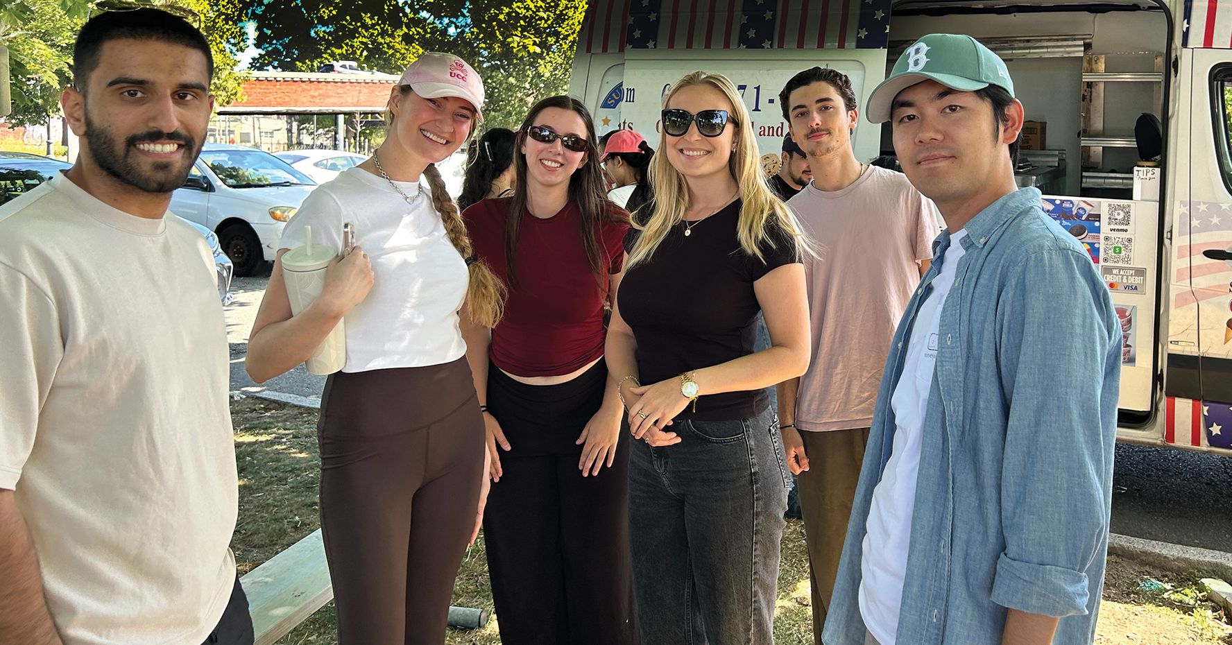 LLM students smile in front of an ice cream truck on a summer day