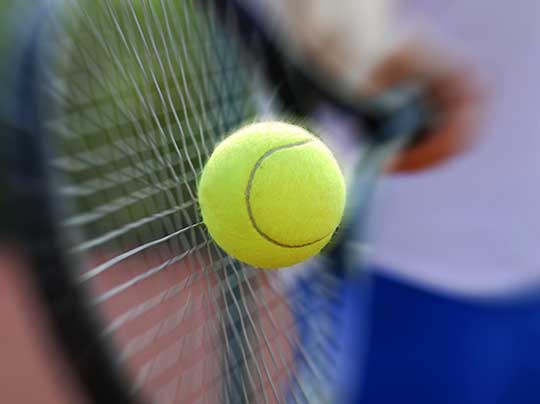 A tennis racquet hitting a ball