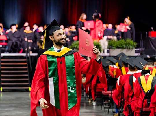 A graduate showing off his diploma during the 2025 MET Convocation ceremony
