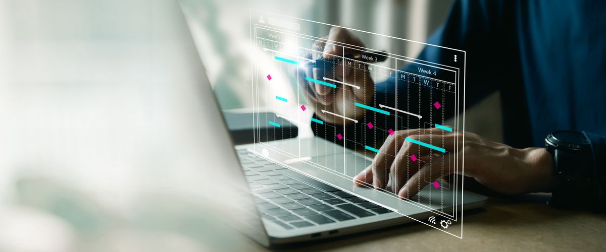 Hands at a laptop keyboard. A calendar schedule is superimposed over the keyboard.