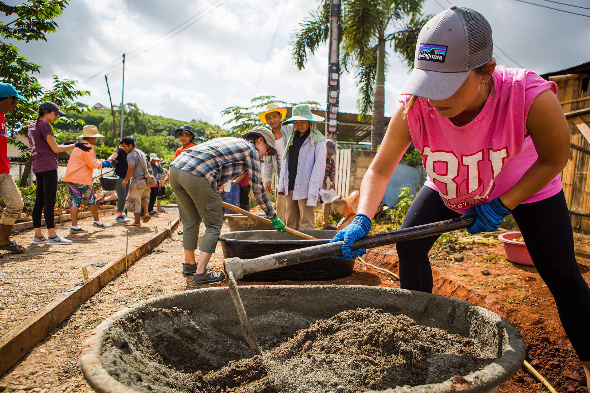 Boston University Sargent School of Health Science and Rehabilitation students help pave a section of road in an Akha hill tribe village in the province of Chiang Rai during a service learning trip to Thailand.