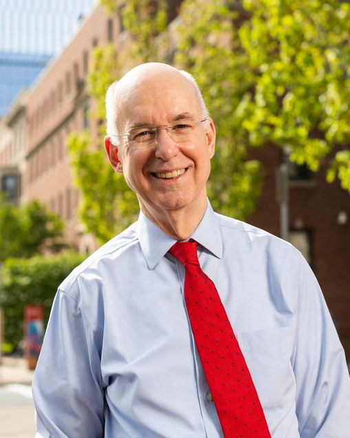 Kenneth Freeman, dean emeritus and professor of the practice at Questrom School of Business, and University vice president and associate provost, has been appointed president ad interim starting August 1 until a permanent replacement has been hired. He stands proudly along Commonwealth Avenue with a smile on a sunny day in front of greenery that's part of Boston University's Center for Computing & Data Sciences.