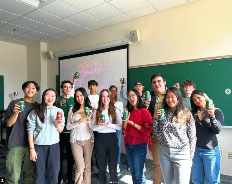 Group of 10+ BU Consulting Club members pose with company swag.