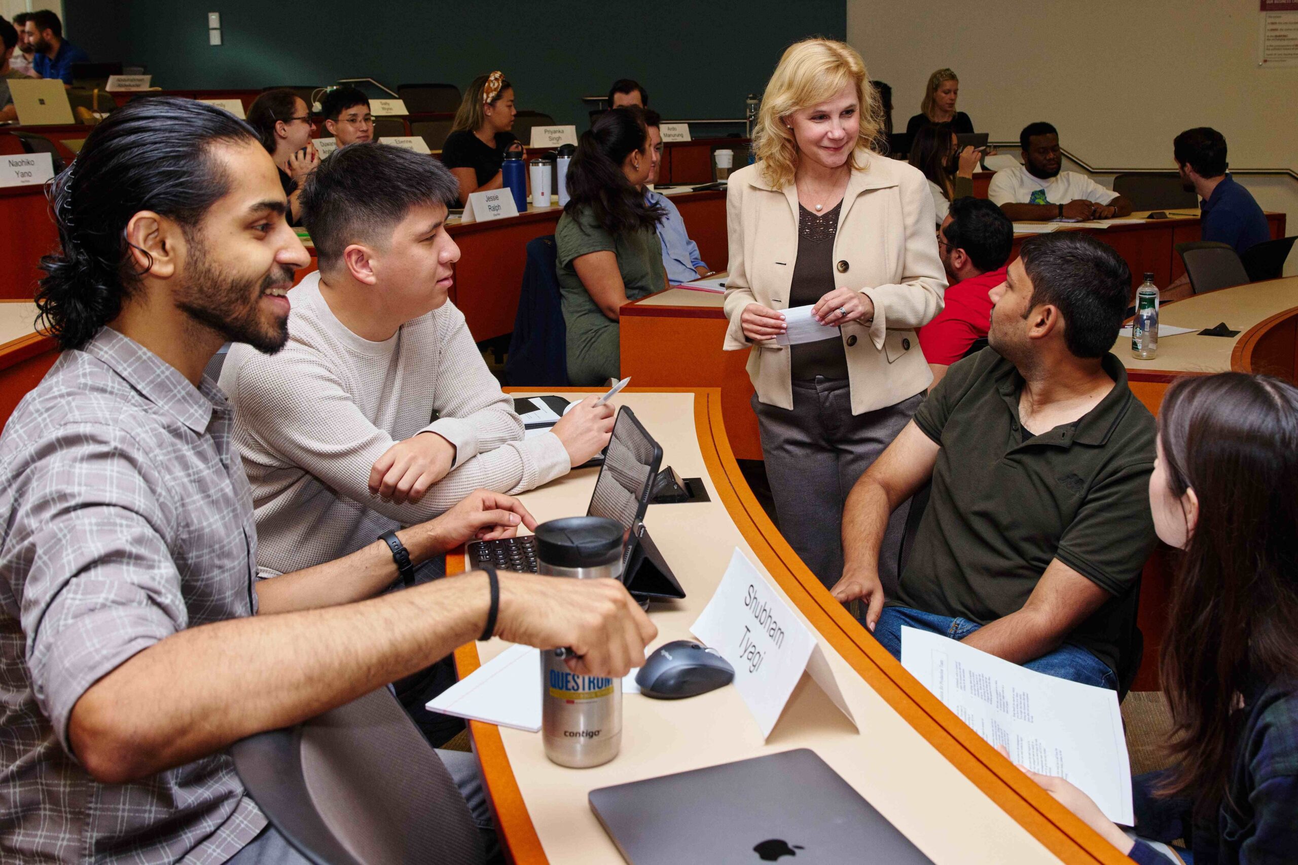 Professor in discussion with a few students during class