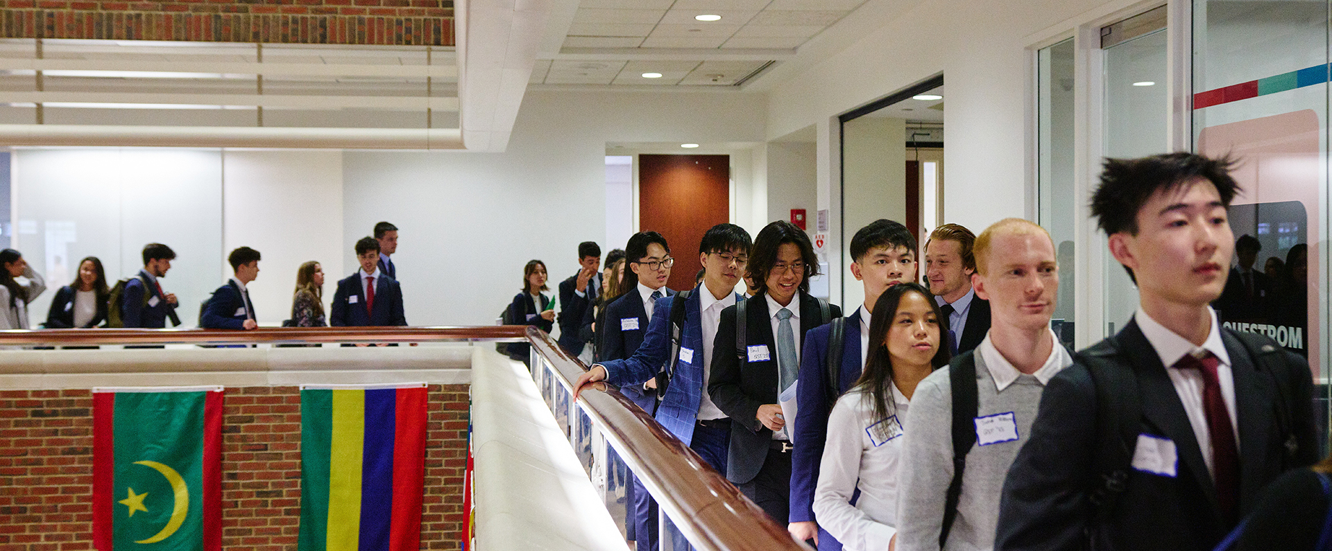 Students walking in a line around second floor of BU building around atrium opening below