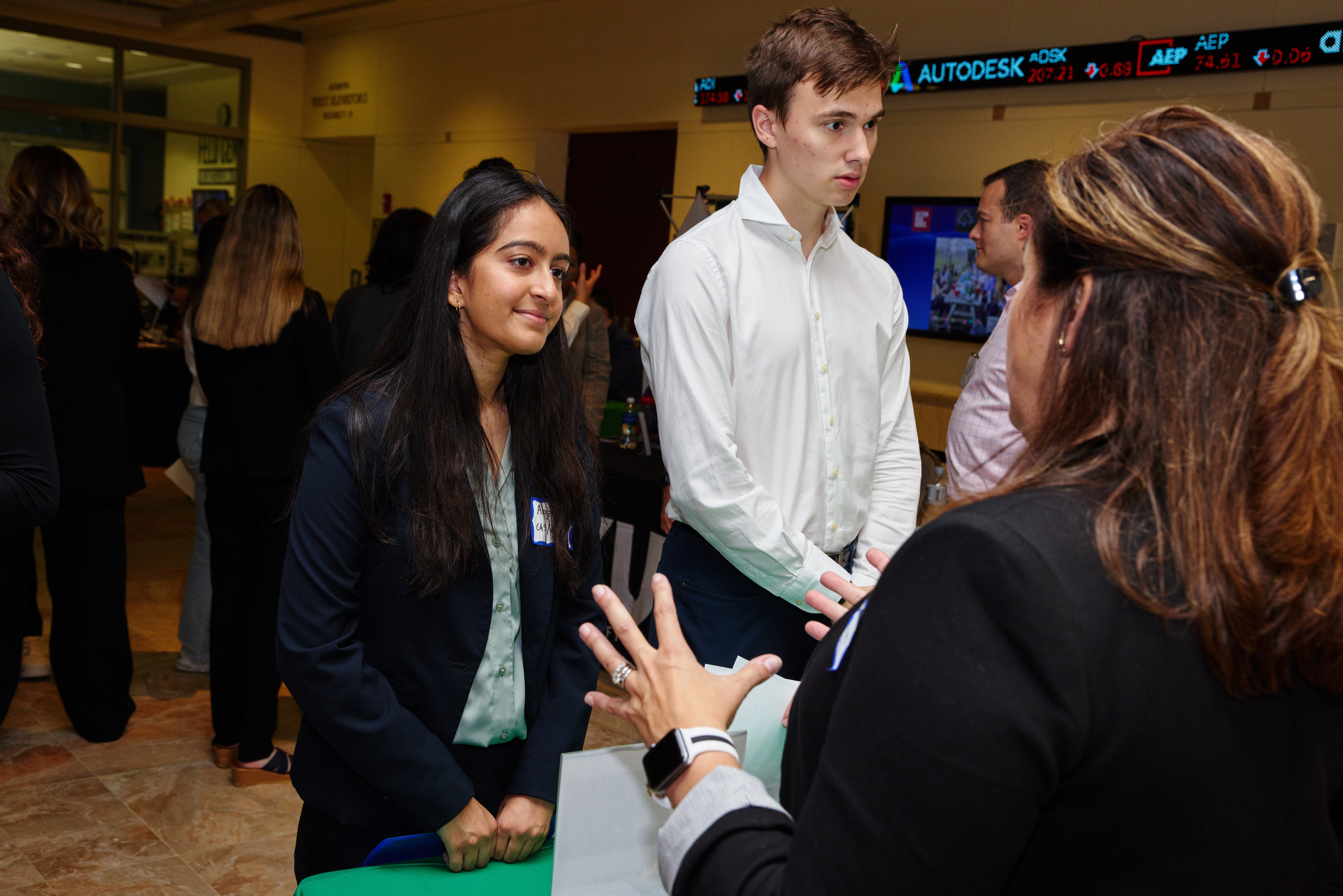 two students speak with an employer at a career fair