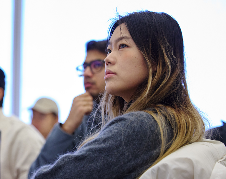 dark haired woman student listening in class