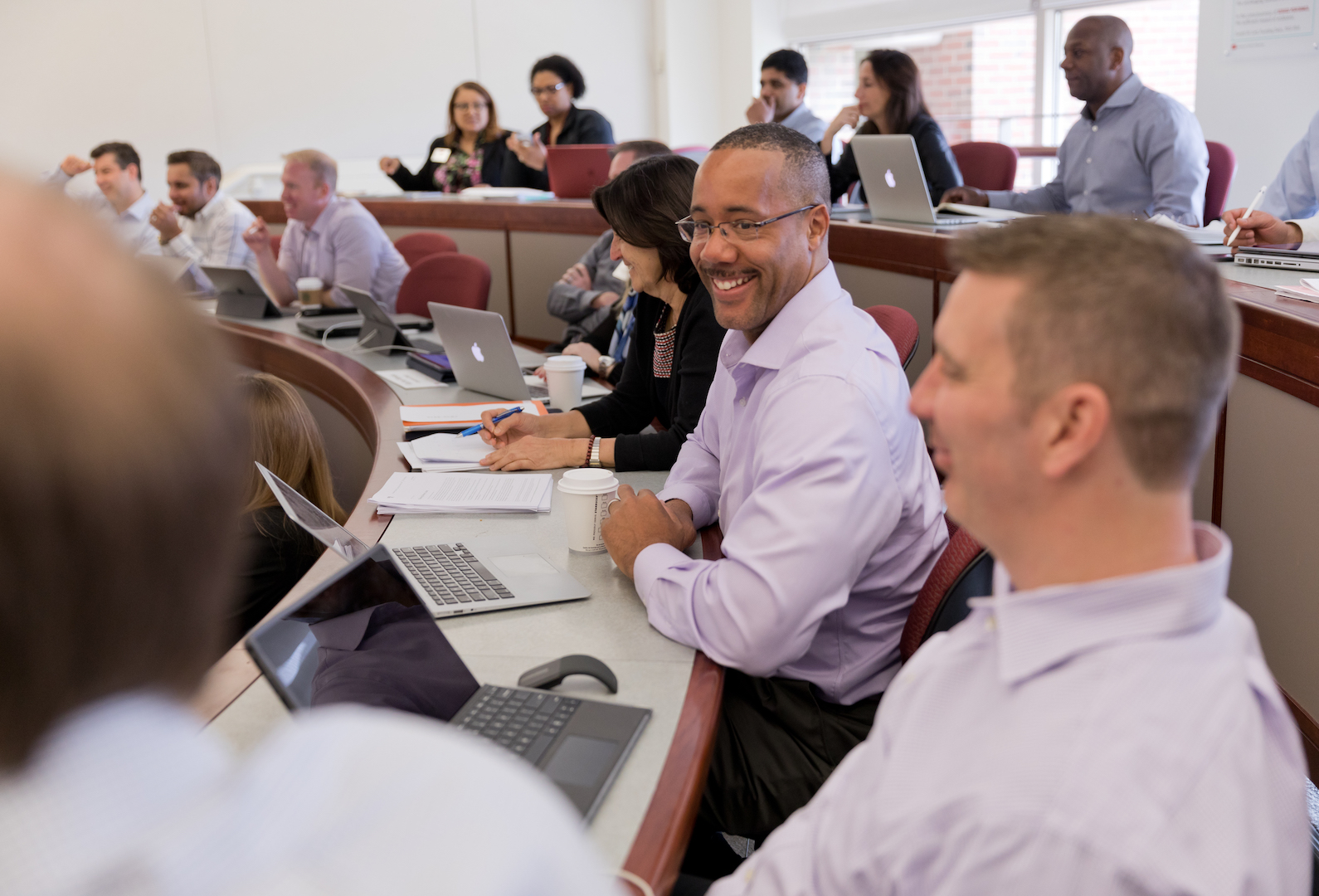 Man smiling at a classmate in an executive education classroom