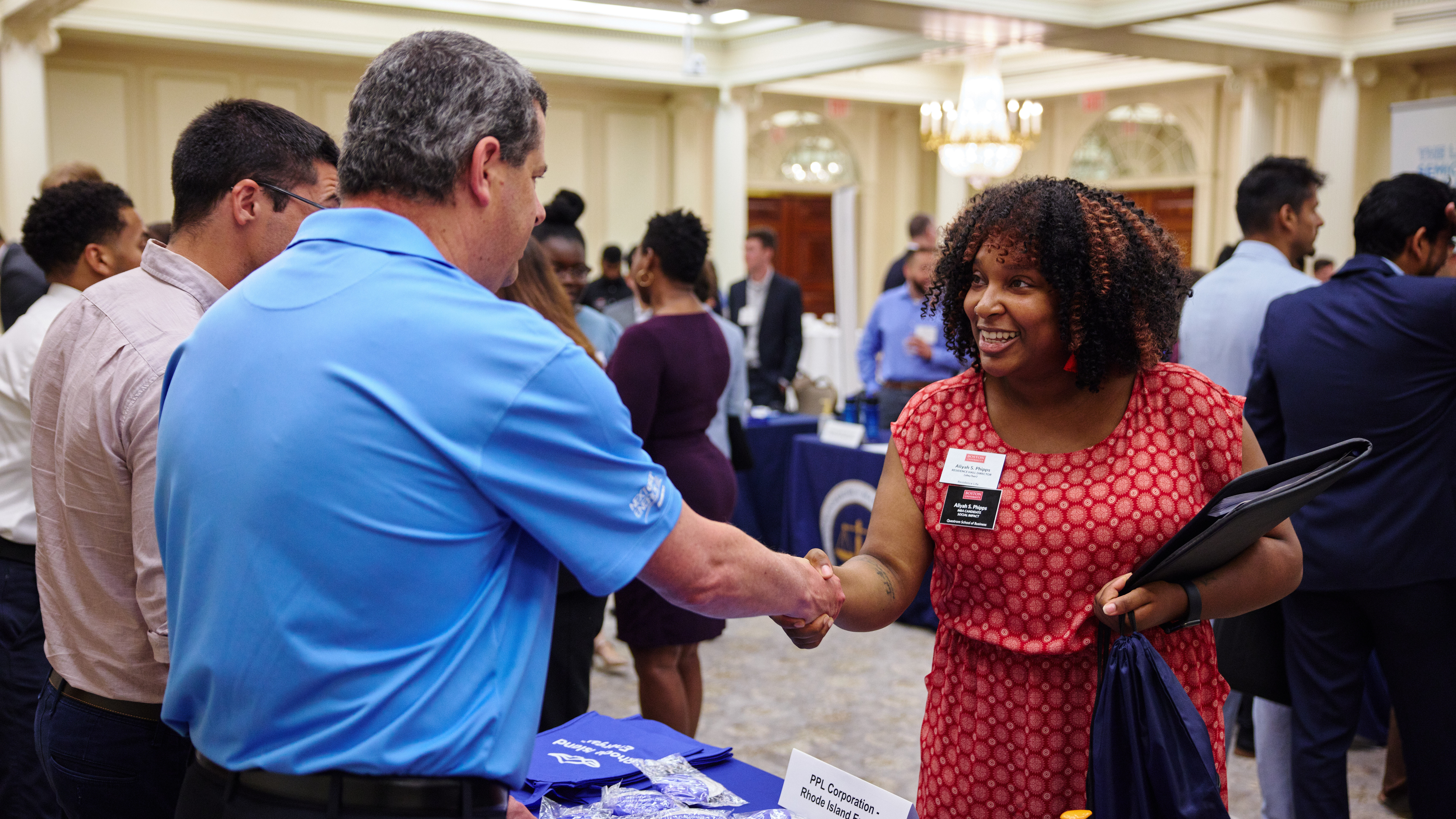 A student shakes the hand of an employer at a career fair