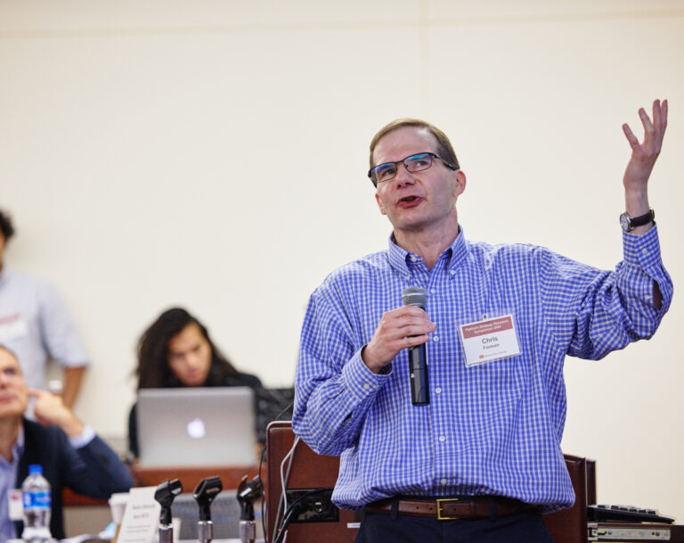 Speaker with a blue shirt holding a microphone