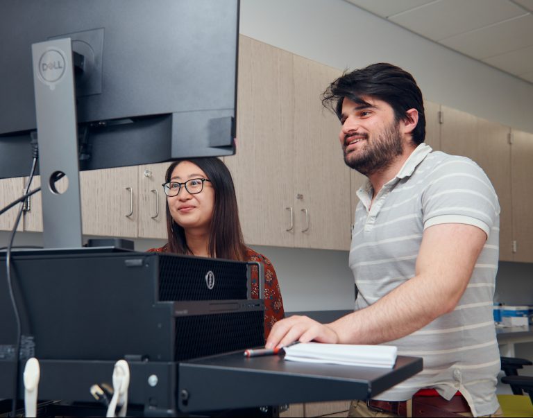 Two researchers looking at computer screen