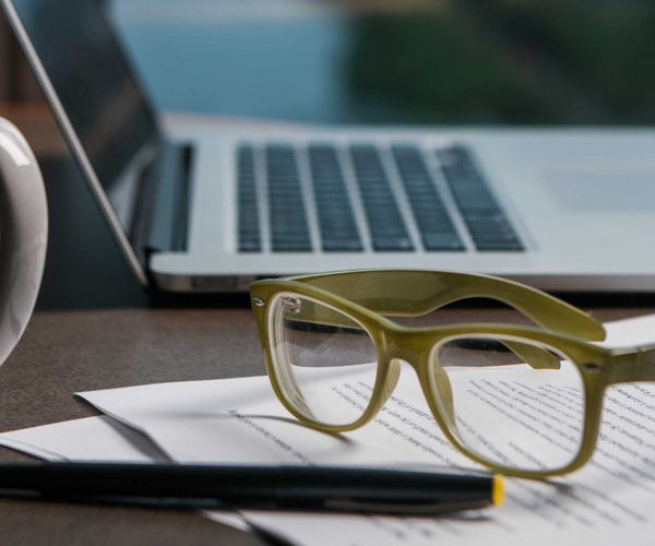 glasses-computer-mug-paperwork-on-desk