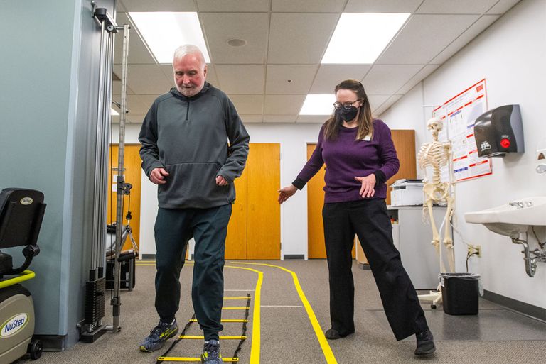 Neurorehabilitation volunteer help Parkinson's patient with physical therapy