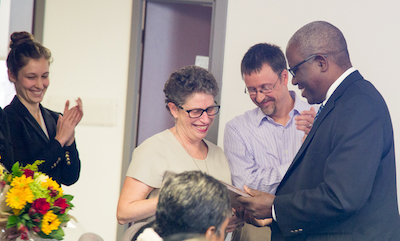 Associate Dean for Public Health Practice Harold Cox, right, presents the Gail Douglas Award to Rachel Goodman and John Kane.