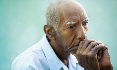 Senior Black man with serious expression deep in thought.