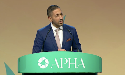 Dean Sandro Galea speaking at a podium that says APHA
