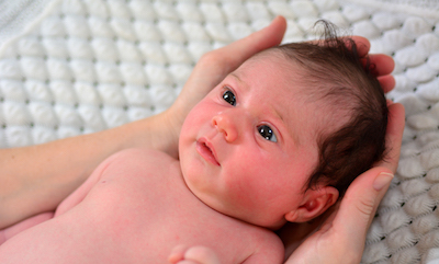 Newborn cradled in mother's hands