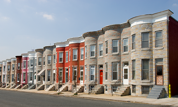 Colorful row houses along a sunny residential, quiet street.