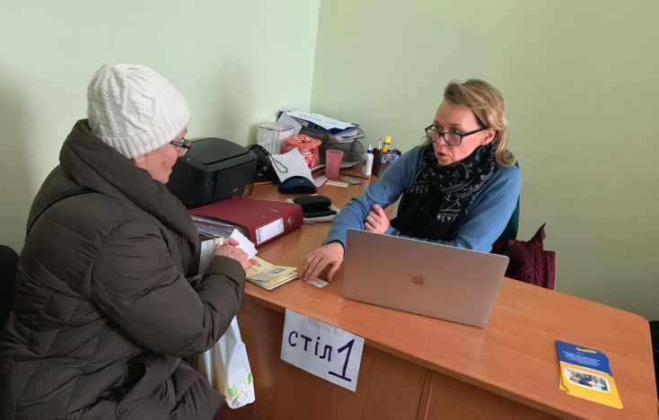 Ukrainian refugee receiving cash at desk