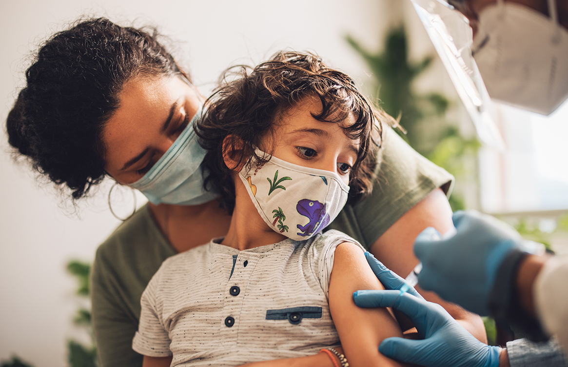 Child receives vaccination while on his mother's lap