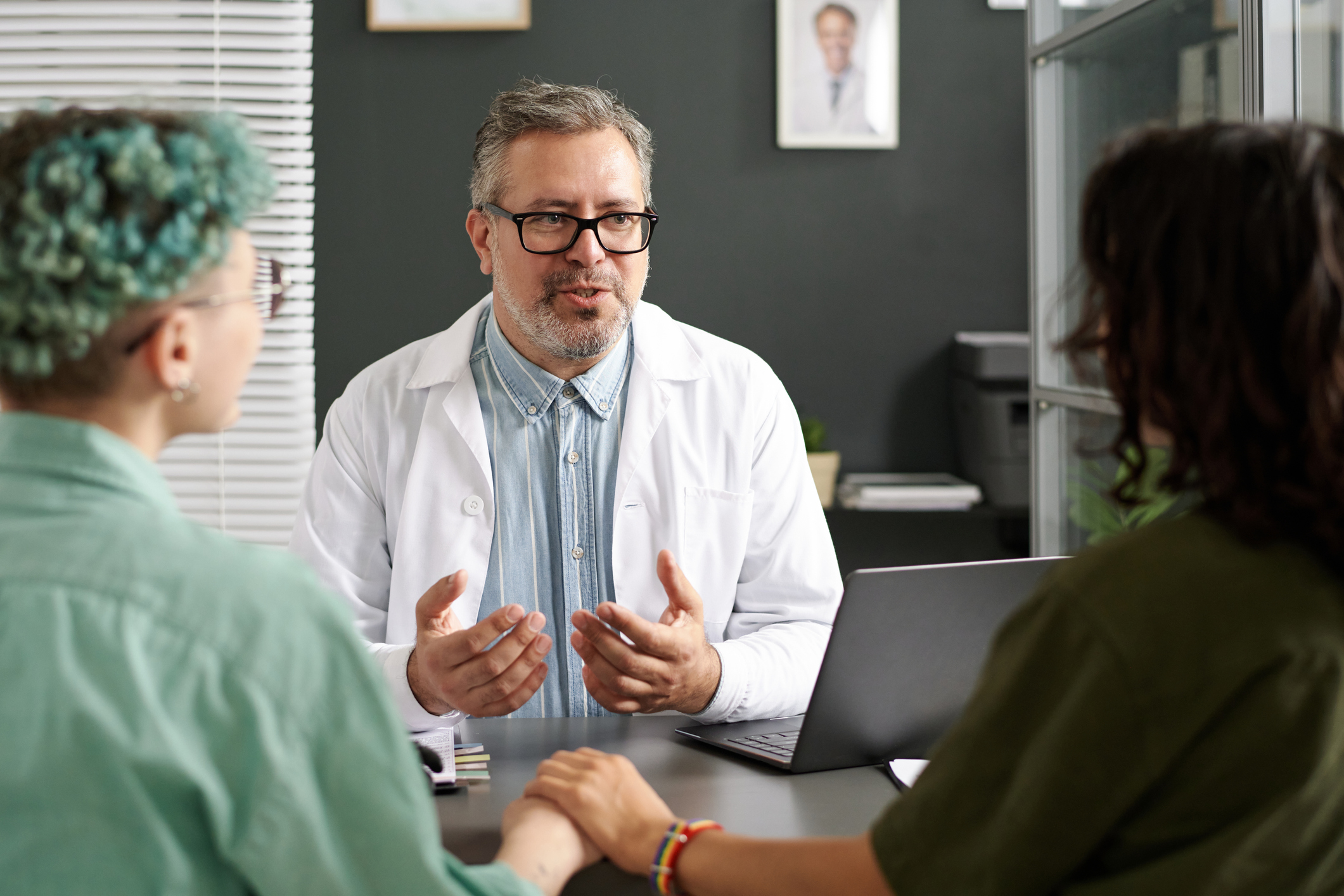 Doctor discussing some questions with lesbian couple during their meeting in office