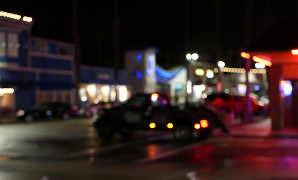 Defocused evening street. Lights of city, cars on rainy night. Road in soft focus.