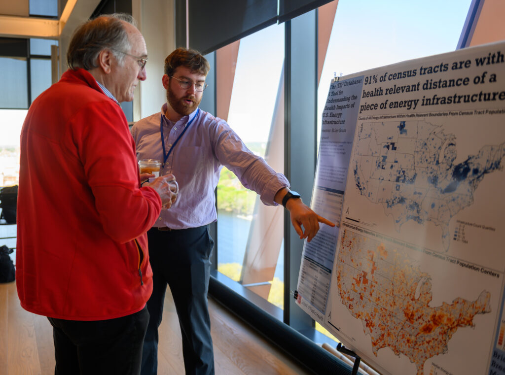 Brian Sousa explains the analysis he has conducted using the EI3 database to a symposium attendee.