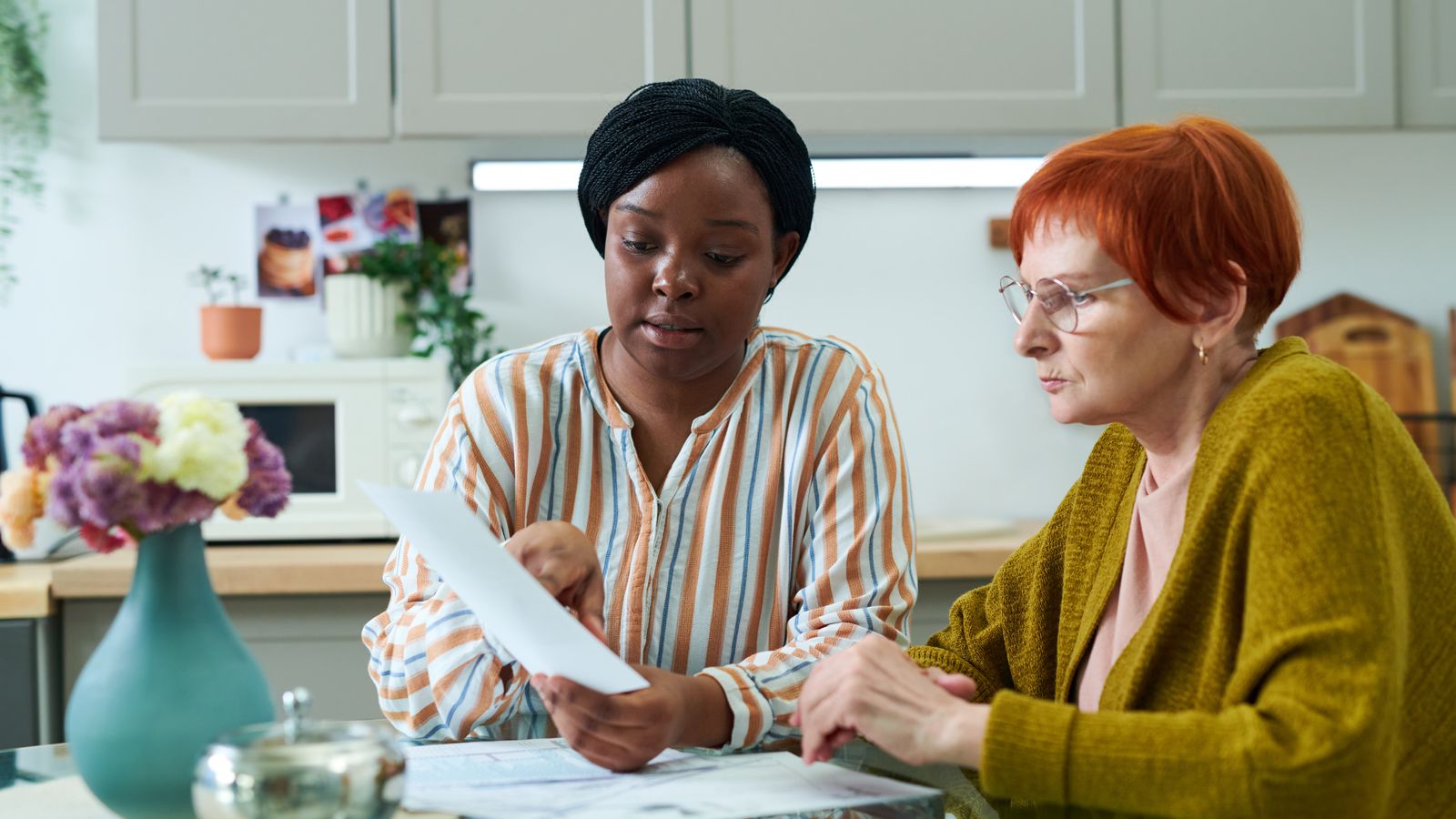 a social worker helping a woman fill out a form