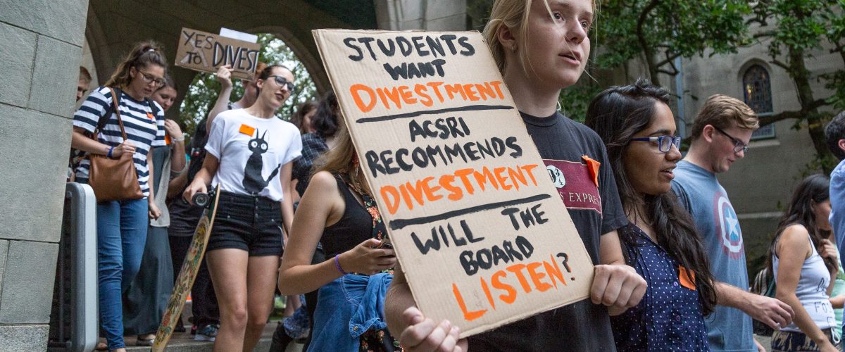 Student holds sign urging for divestment at DIvestBU rally