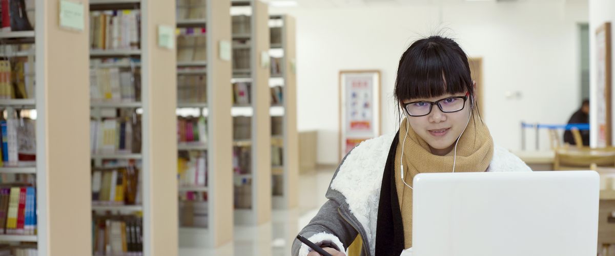 Person using a laptop in a library