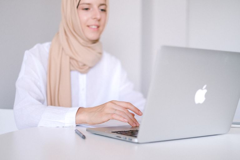 Woman in white shirt using a laptop