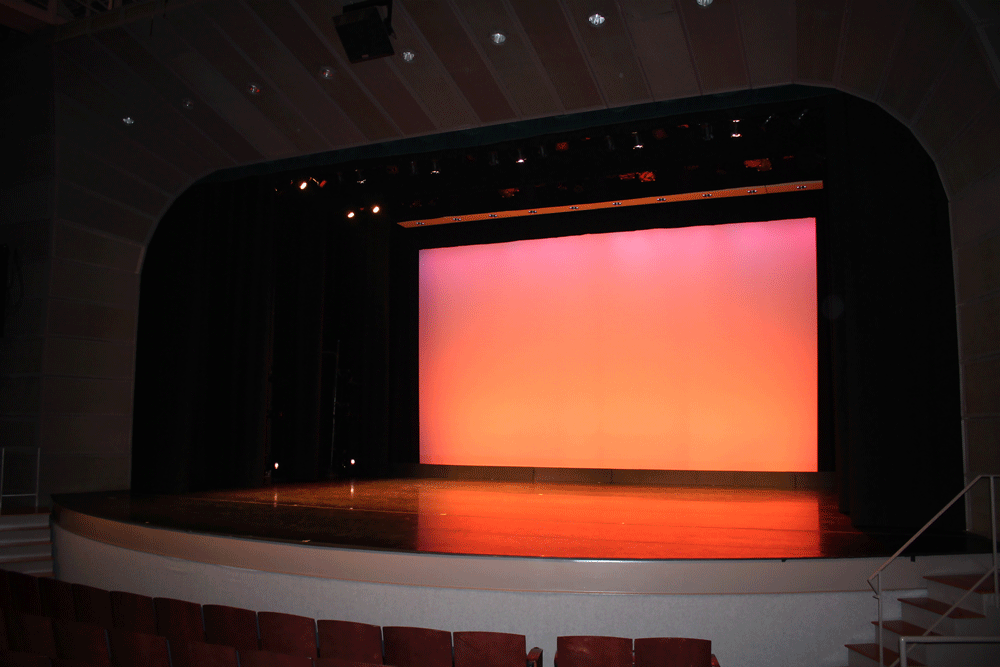 Empty stage preset with black dance floor, black curtain legs, and pinkish-orange light on cyclorama.