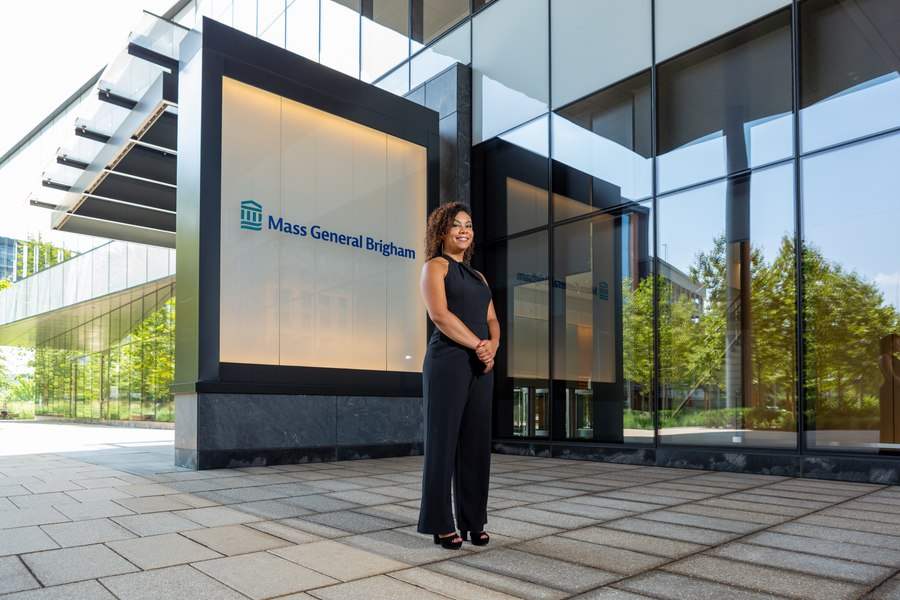 Women in black jumpsuit stands in front of Mass General Sign