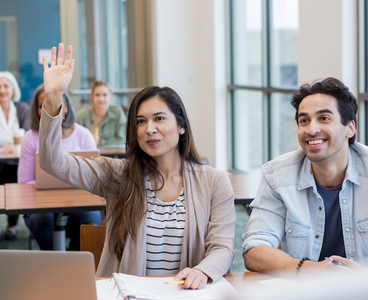 male and female student sitting in front of class listening to instructor