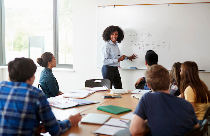 female teacher reviewing math with students