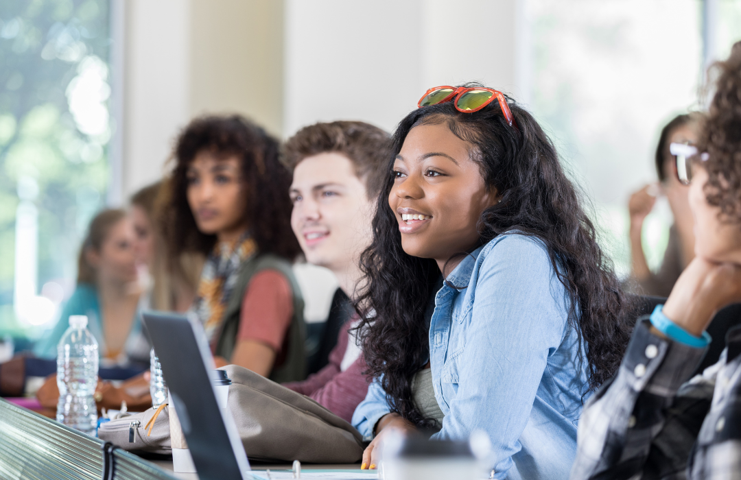 black student smiling during class surrounded by fellow classmates