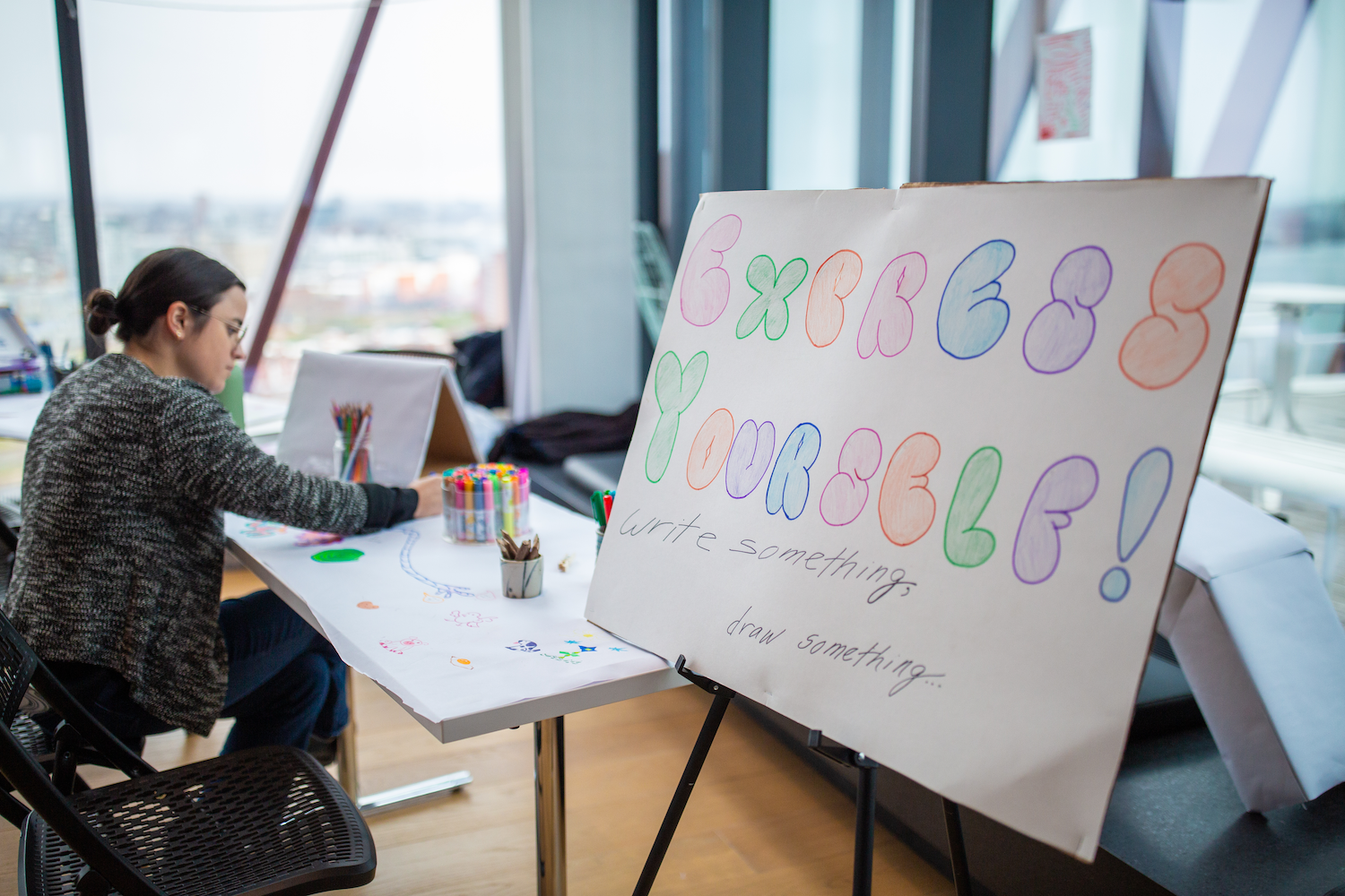 Poster on easel reading in colorful rainbow letters reading "express yourself"